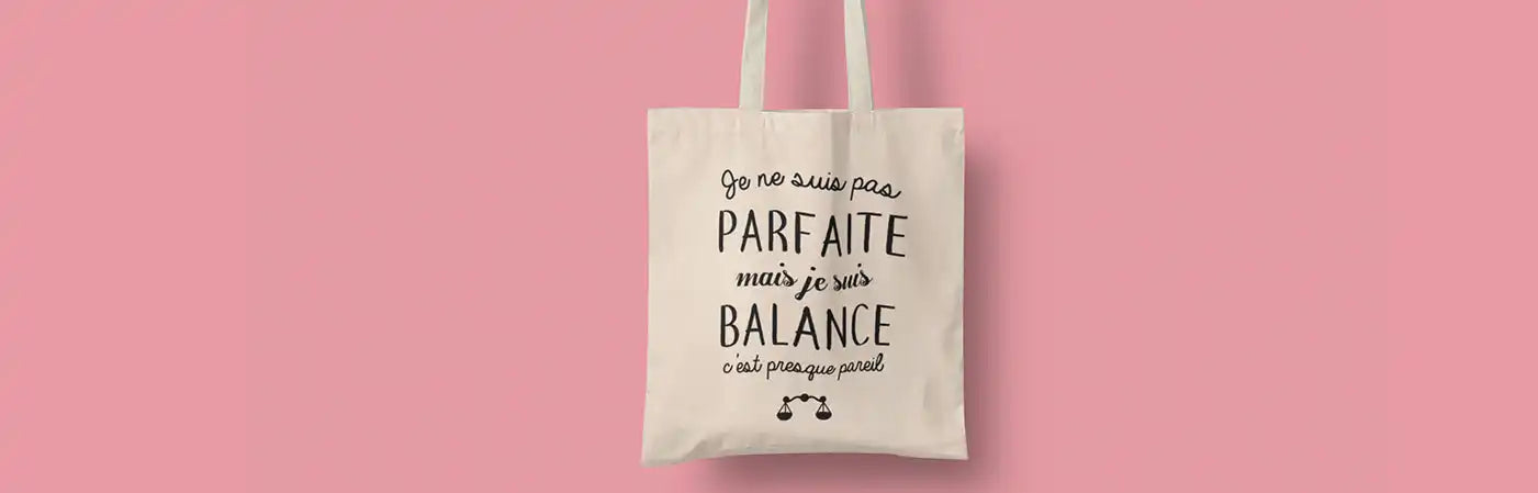 Sac fourre-tout en toile blanc cassé avec écriture noire et un petit graphique.