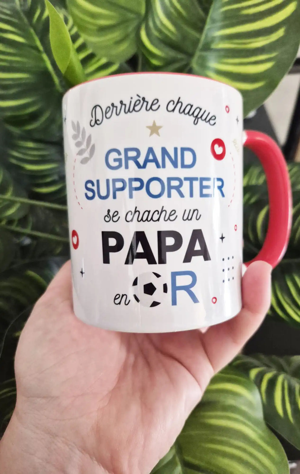 Une tasse en céramique blanche avec une poignée rouge et un motif sur le thème du football.