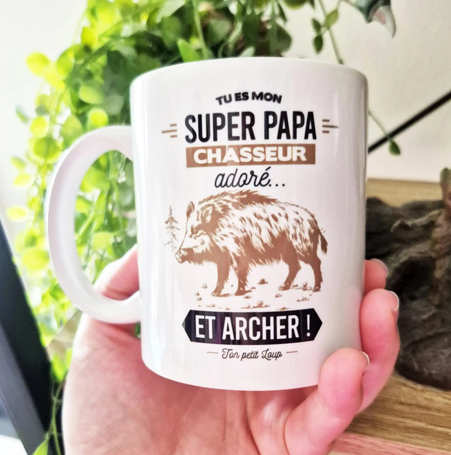 Une tasse en céramique blanche avec une illustration de sanglier et du texte en français.