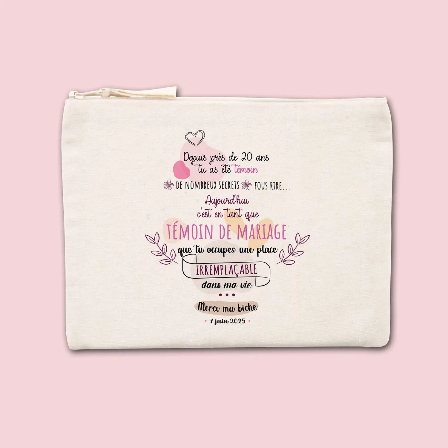 Une pochette rectangulaire de couleur crème avec une fermeture éclair, ornée de texte décoratif en rose et noir.