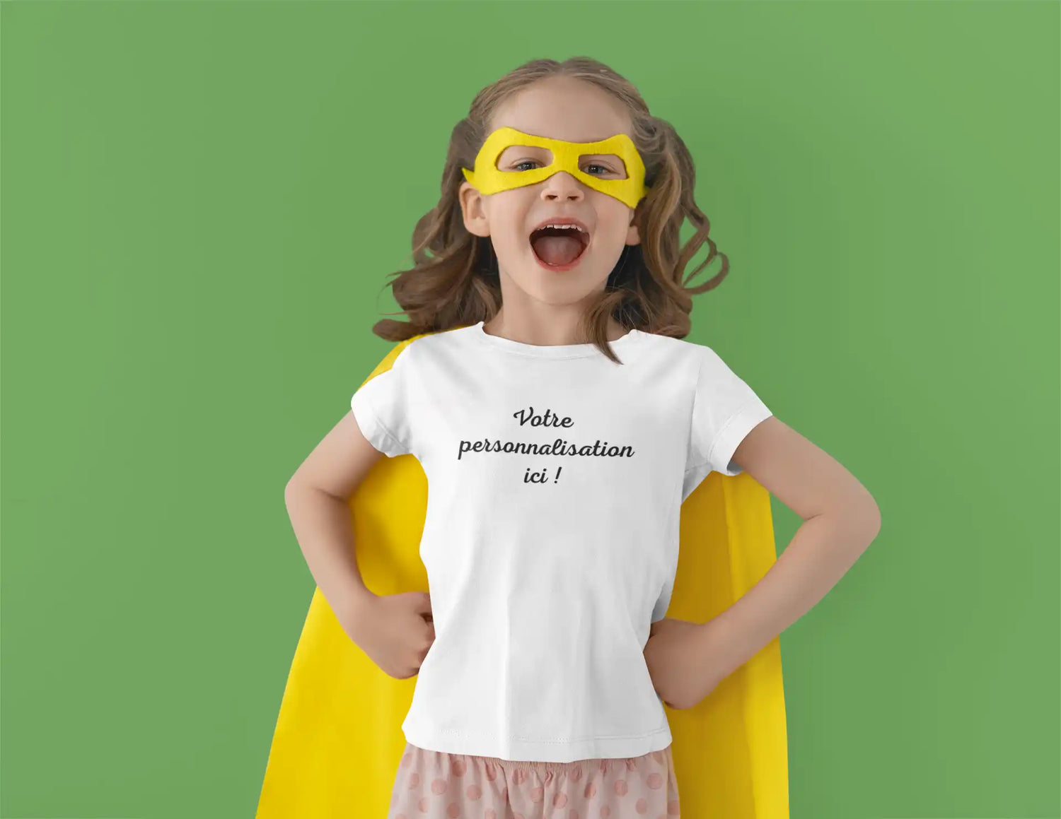 Une jeune fille portant un t-shirt blanc, un masque de super-héros jaune et une cape jaune.