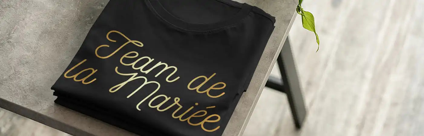 Un t-shirt noir avec des lettres en script doré.