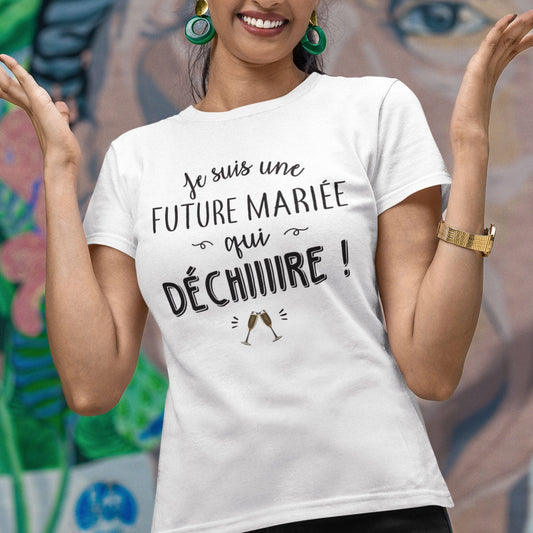 T-shirt femme blanc avec l'inscription 'Future mariée qui déchire' en lettres stylisées, conçu pour les futures mariées prêtes à briller avec humour et style. Ce design amusant et unique est idéal pour célébrer l'un des moments les plus importants de la vie.