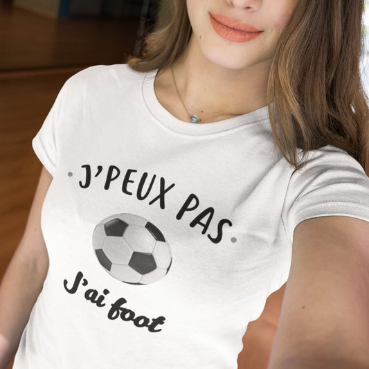 T-shirt femme blanc avec l'inscription "J'peux pas, j'ai foot", idéal pour les passionnées de football. Confortable et stylé, parfait pour afficher son amour du sport au quotidien.